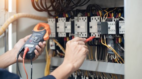 un électricien qui cherche une panne sur un disjoncteur